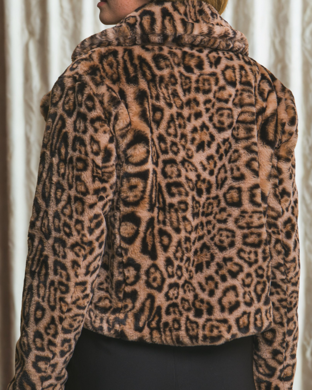 Leopard print jacket worn by a person with a neutral background