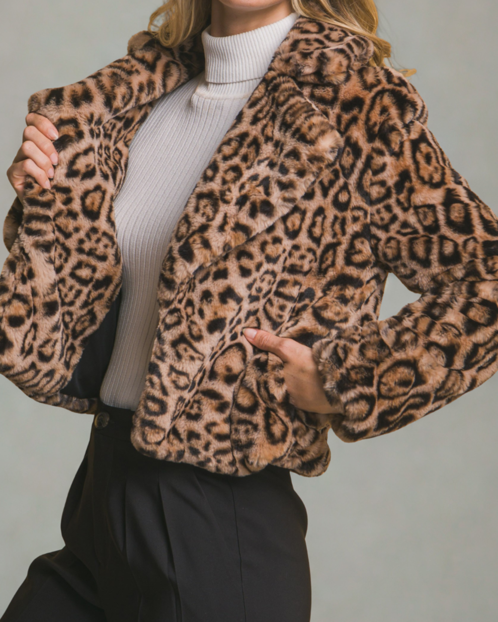Person wearing a leopard print jacket against a neutral background